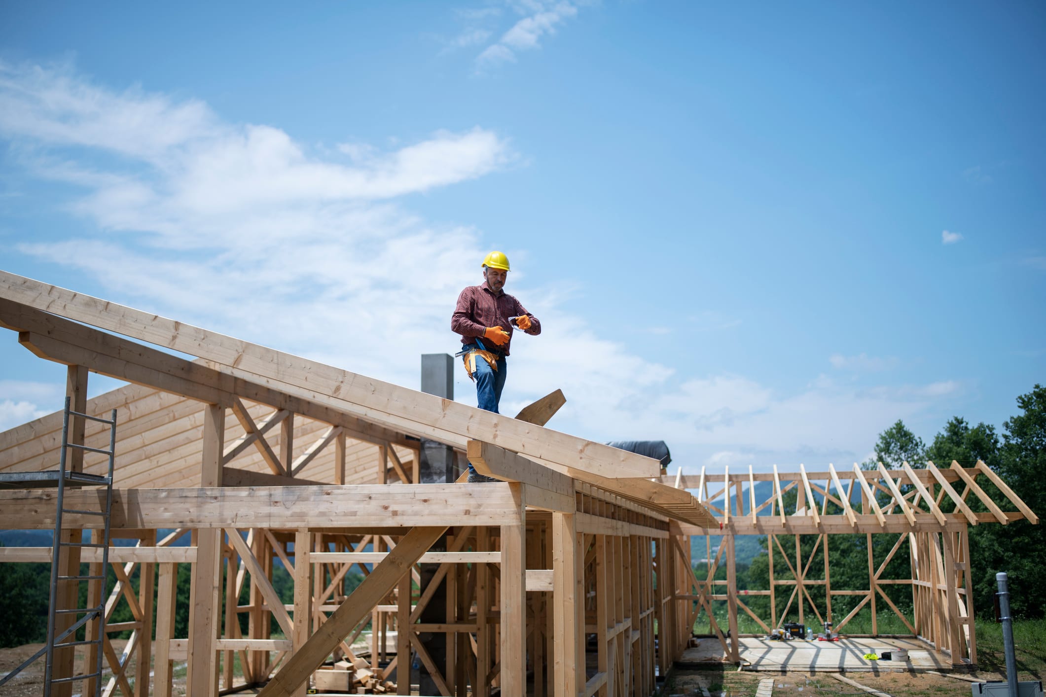 Carpenter working on the roof of a wooden house.