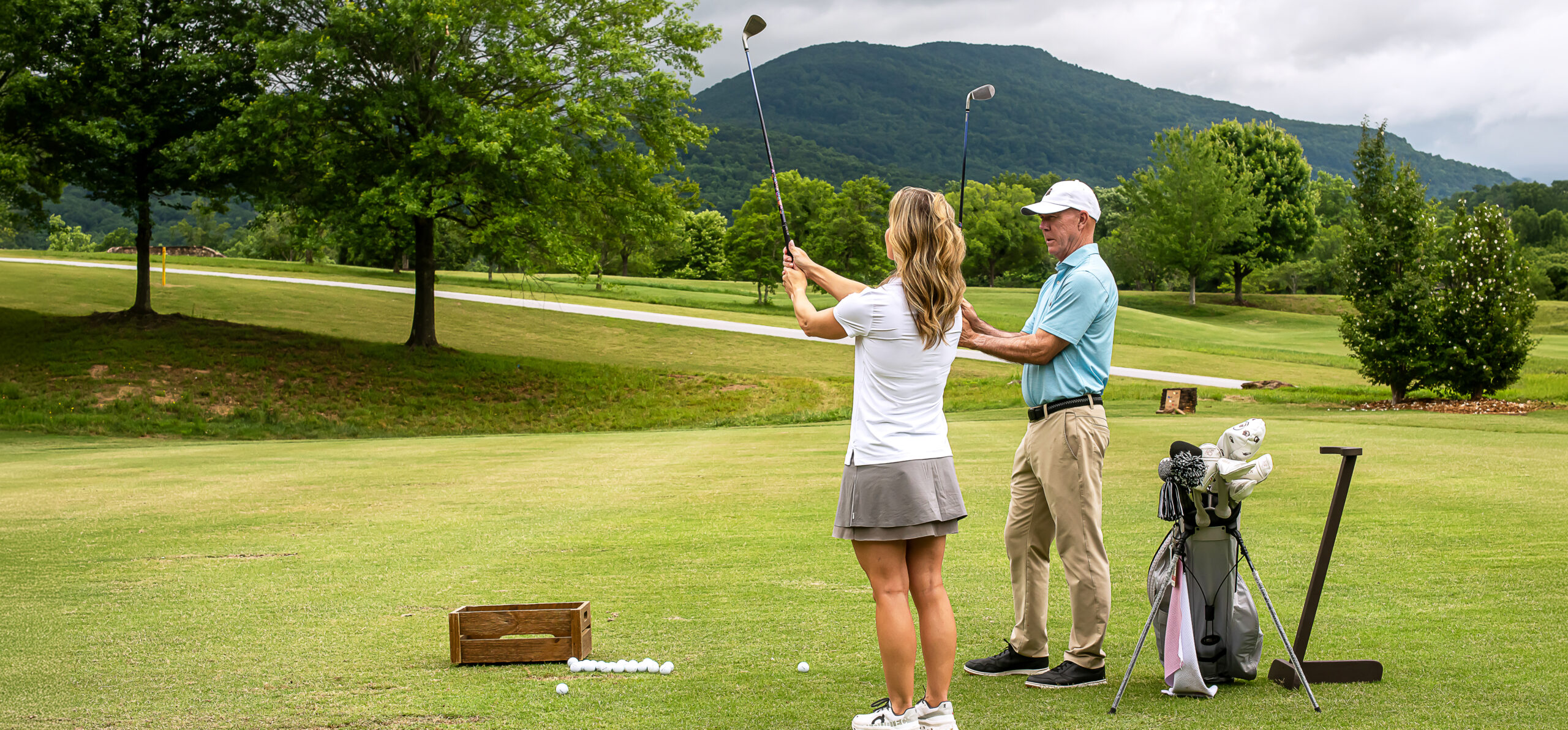 golf coach teaches woman to swing