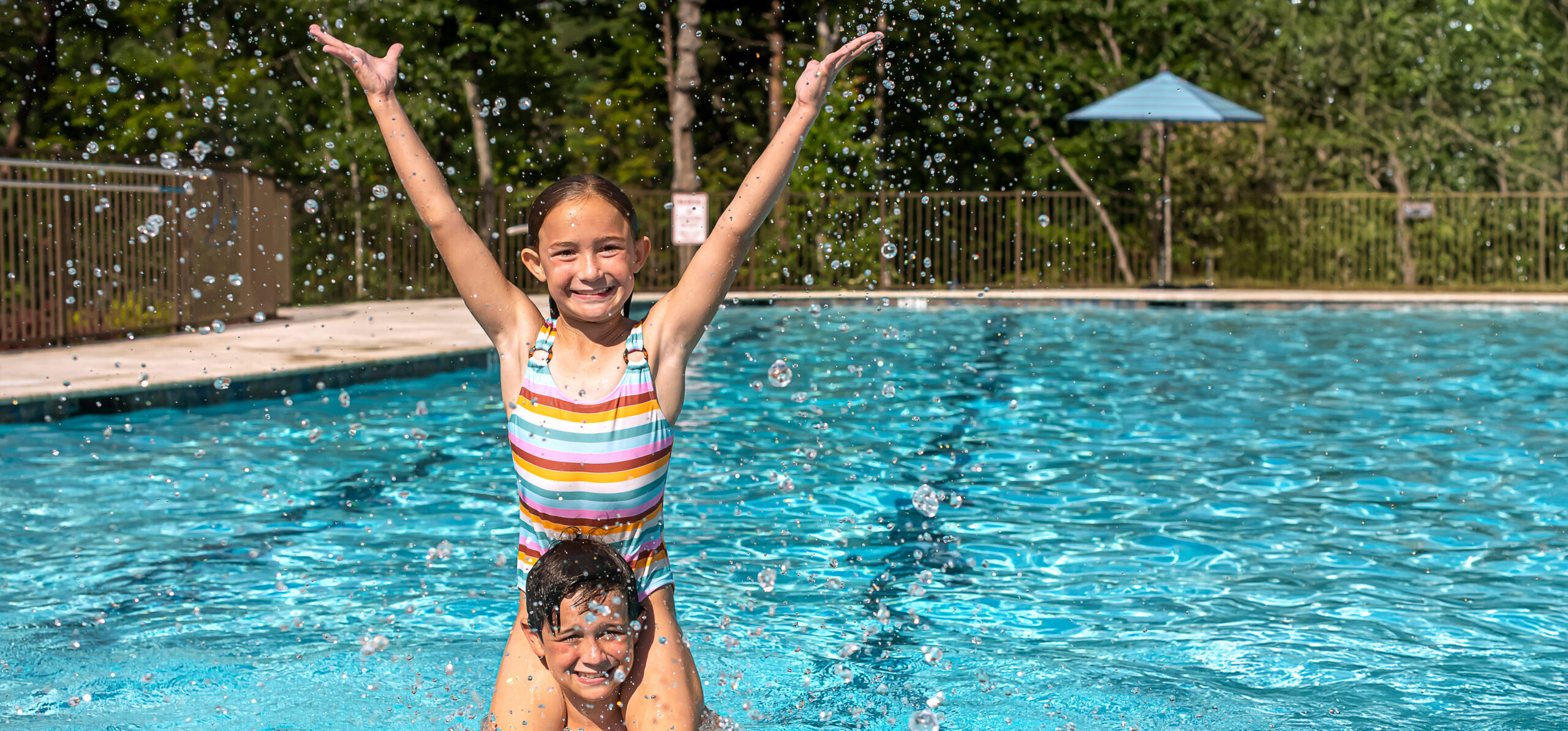 2 children smile and play in pool