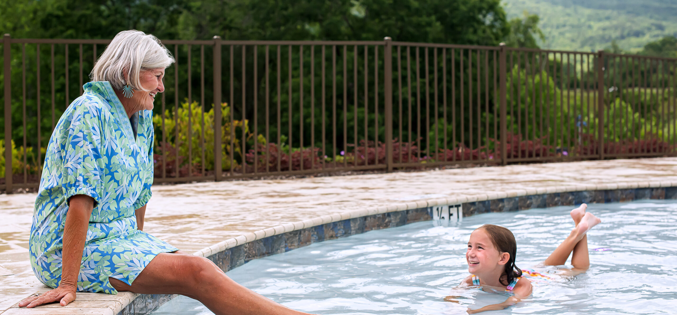 grandmother smiles at grandaughter in pool