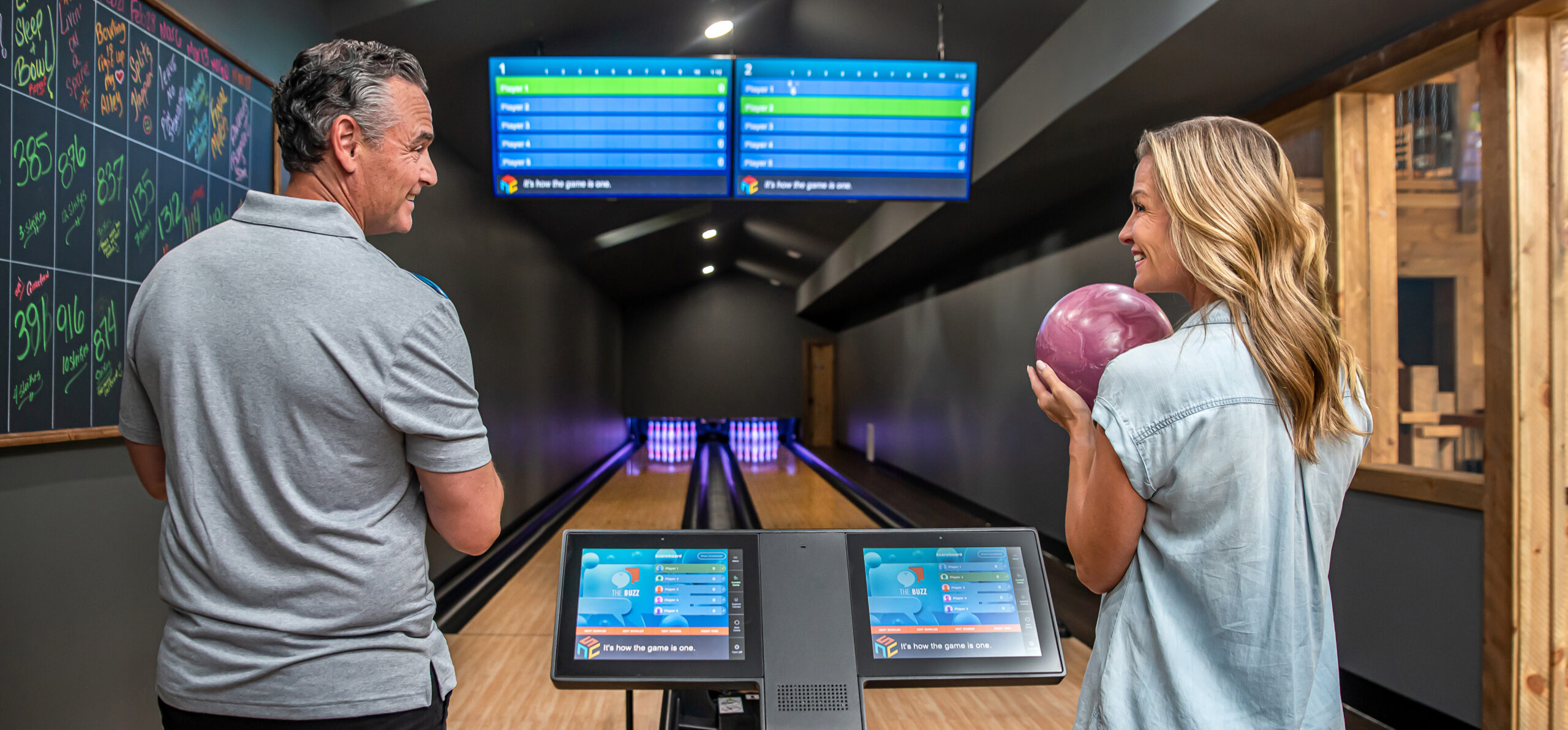 couple at bowling alley smiles at each other